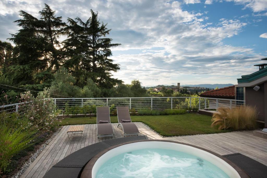 a backyard with a hot tub and two chairs at Dame di Toscana in Lastra a Signa