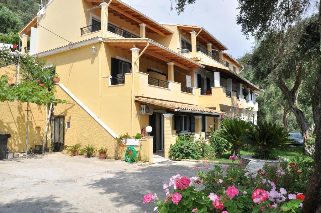 a yellow building with flowers in front of it at Lidovois House in Pelekas