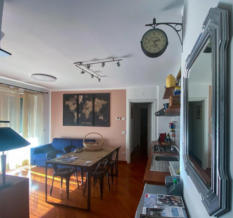 a living room with a table and a clock on the wall at Living Rencio: vicino al Centro di Bolzano in Bolzano