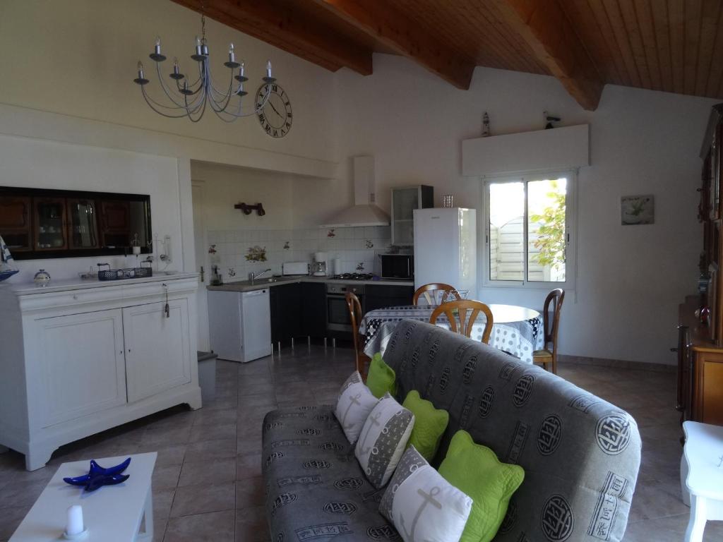 ein Wohnzimmer mit einem Sofa und einer Küche in der Unterkunft Gite 3 étoiles les Nougers in La Tremblade