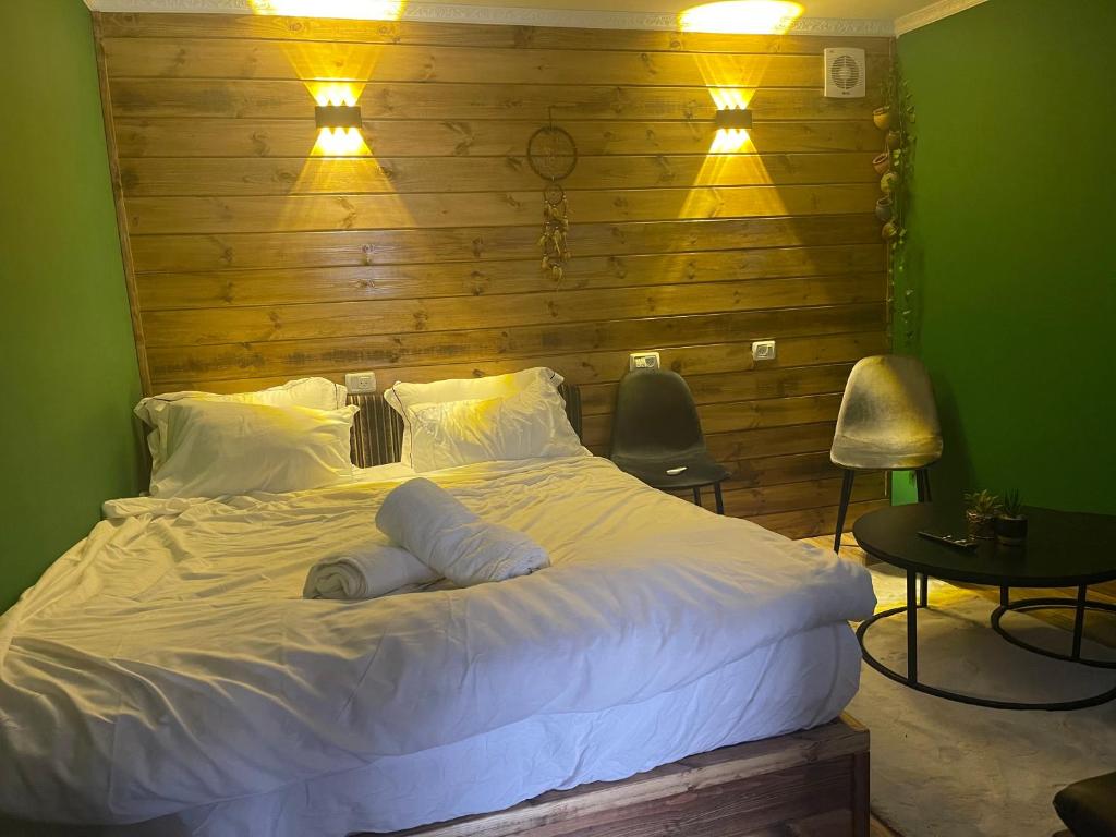 um quarto com uma grande cama branca e uma parede de madeira em Cozy em Majdal Shams