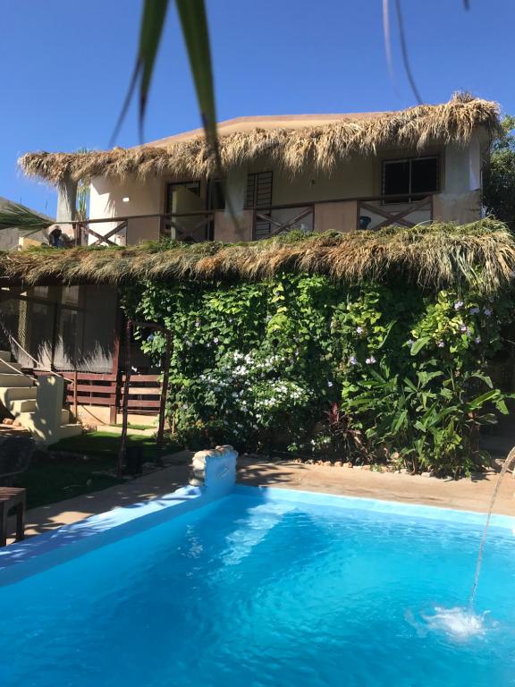 a villa with a swimming pool in front of a house at ECOVILLA CORAL GARDEN in Baoruco