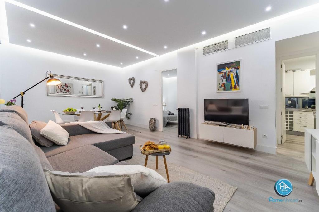a living room with a couch and a tv at Boutique Madrid Center Apartment in Madrid