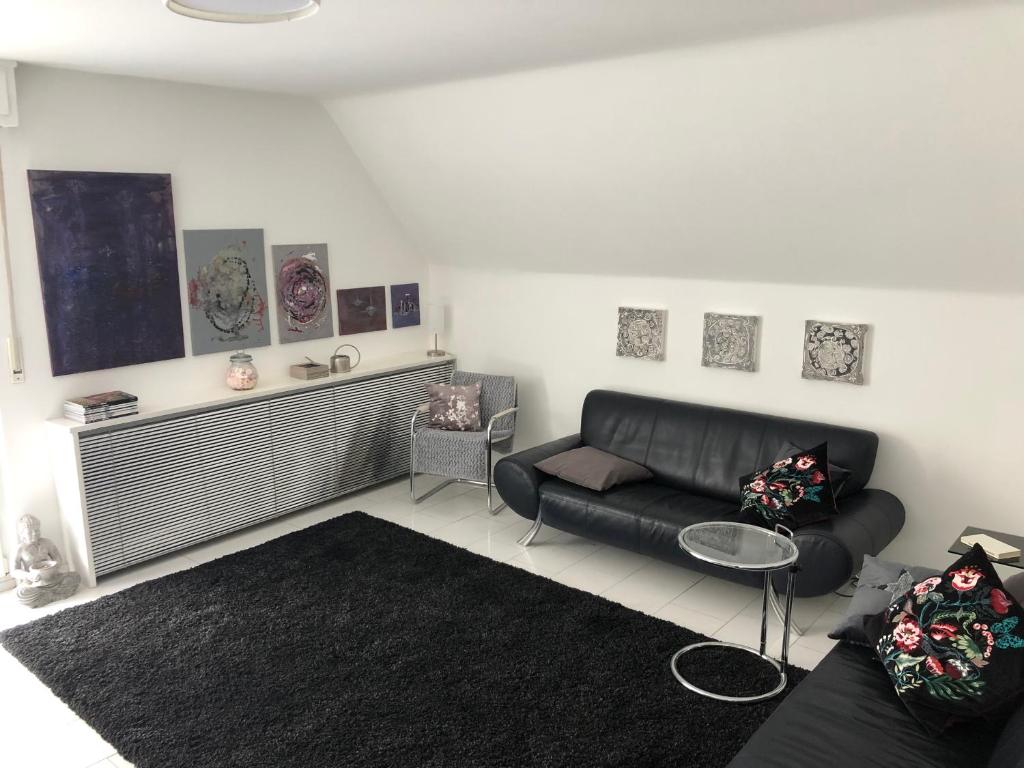 uma sala de estar com um sofá de couro preto em Bel Art Etage em Haan