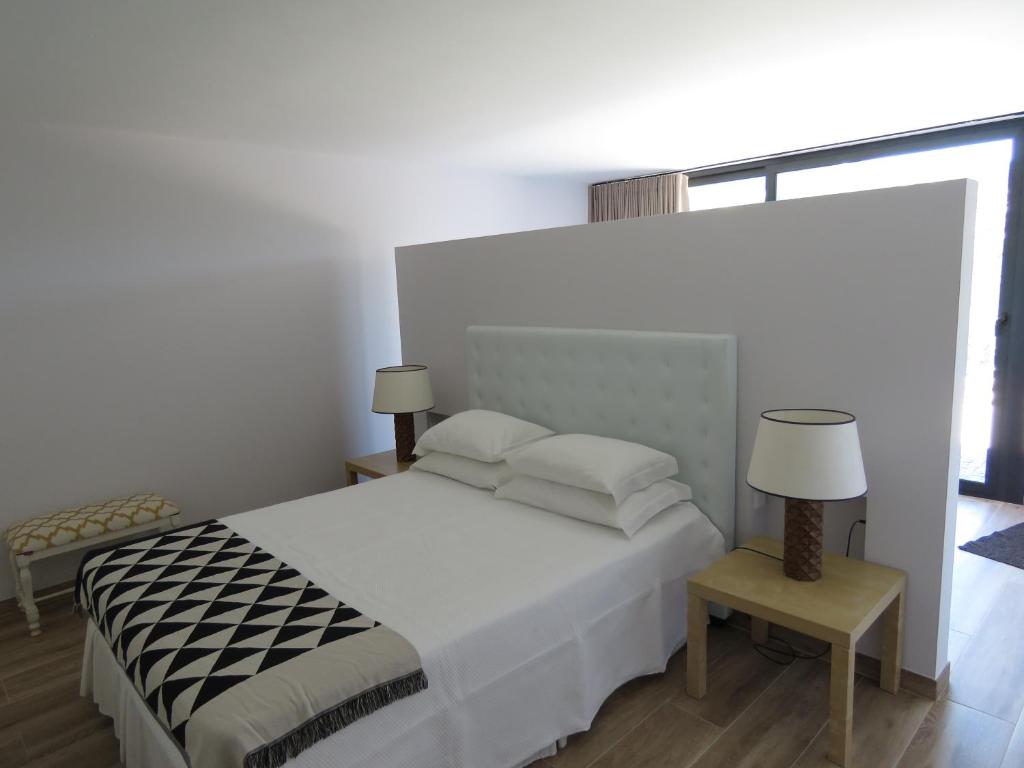 a white bedroom with a bed and a window at Paco de Pombeiro - Turismo de Habitacao in Felgueiras