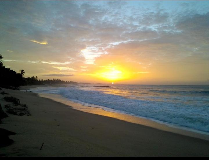 a sunset on the beach with the sun setting at Dilip's House in Tangalle