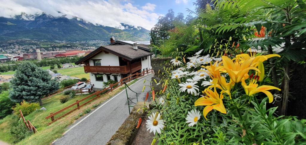 a house with flowers on the side of a road at Agriturismo B&B Chèvres à Cheval in Aosta