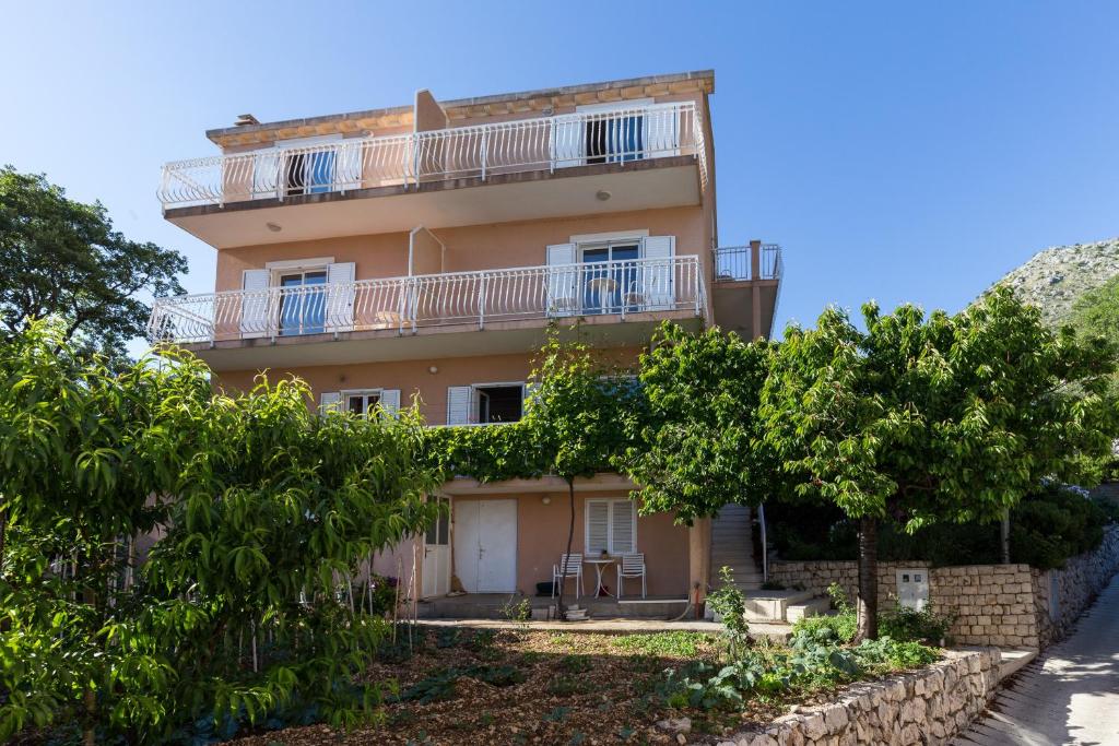 un edificio de apartamentos con balcón y árboles en Villa Dubravka, en Mlini