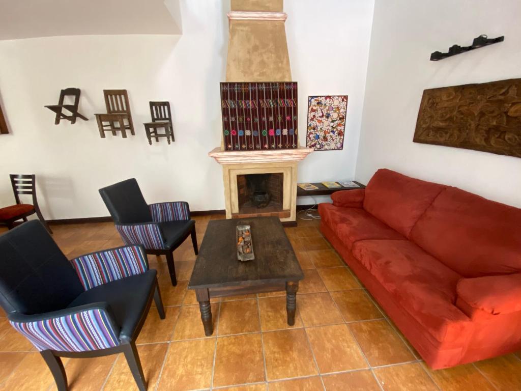 ein Wohnzimmer mit einem roten Sofa und einem Kamin in der Unterkunft Suite don Pedro: Hermoso Loft con parqueo gratis! in Antigua Guatemala