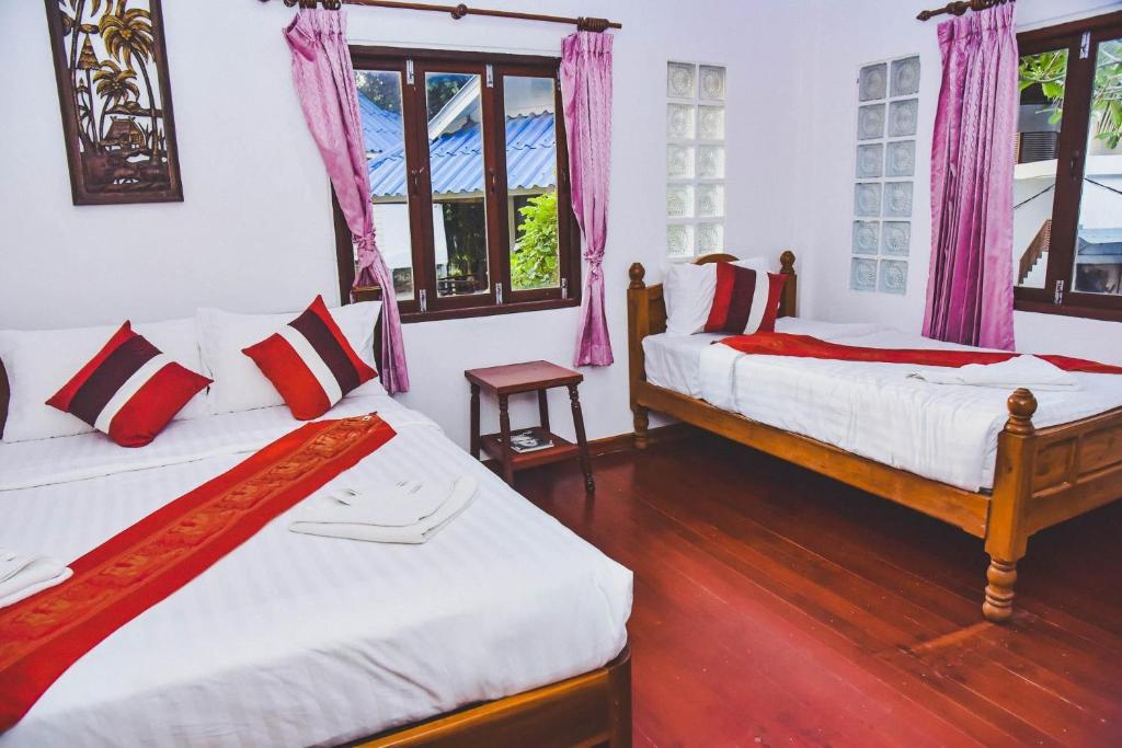 タオ島にあるPranee Bungalowのピンクのカーテンが備わるドミトリールームのベッド2台