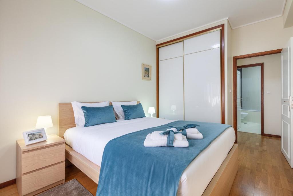 ein Schlafzimmer mit einem großen Bett mit blauen Kissen in der Unterkunft RH Charming Apartment - T3 in Barcelos