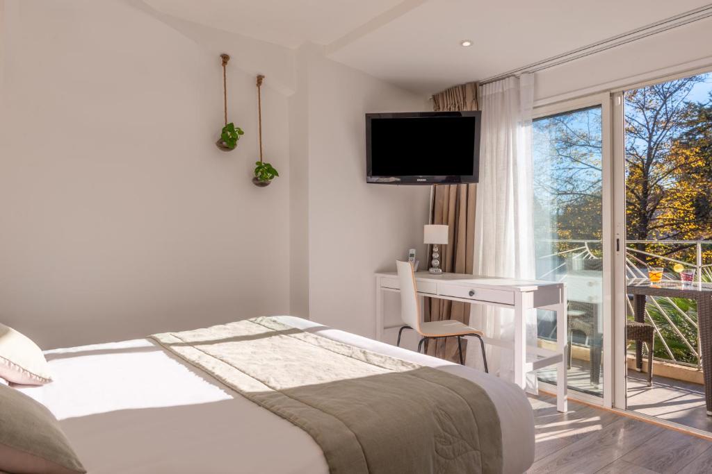 una camera con letto, scrivania e finestra di La Bastide a La Colle-sur-Loup