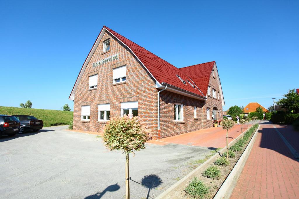 un edificio in mattoni con un albero di fronte di Hotel Seewind a Norddeich