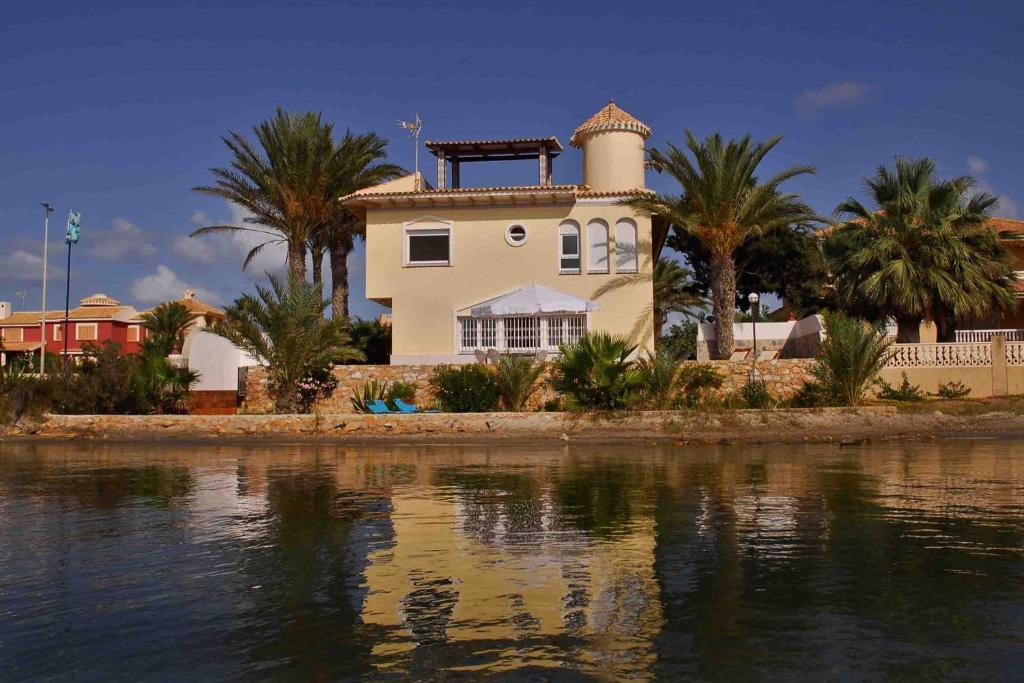una casa en la orilla de un cuerpo de agua en Villa Las Palmeras en La Manga del Mar Menor