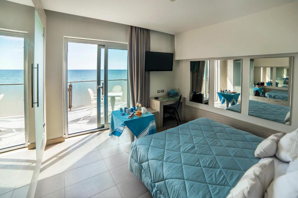 a bedroom with a bed and a view of the ocean at Smy Aran Blu Roma Mare in Lido di Ostia