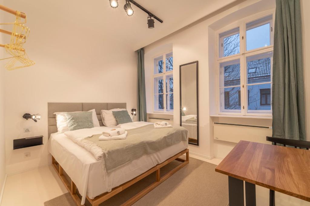 a bedroom with a bed and a table and windows at Albrecht I levestate in Vienna