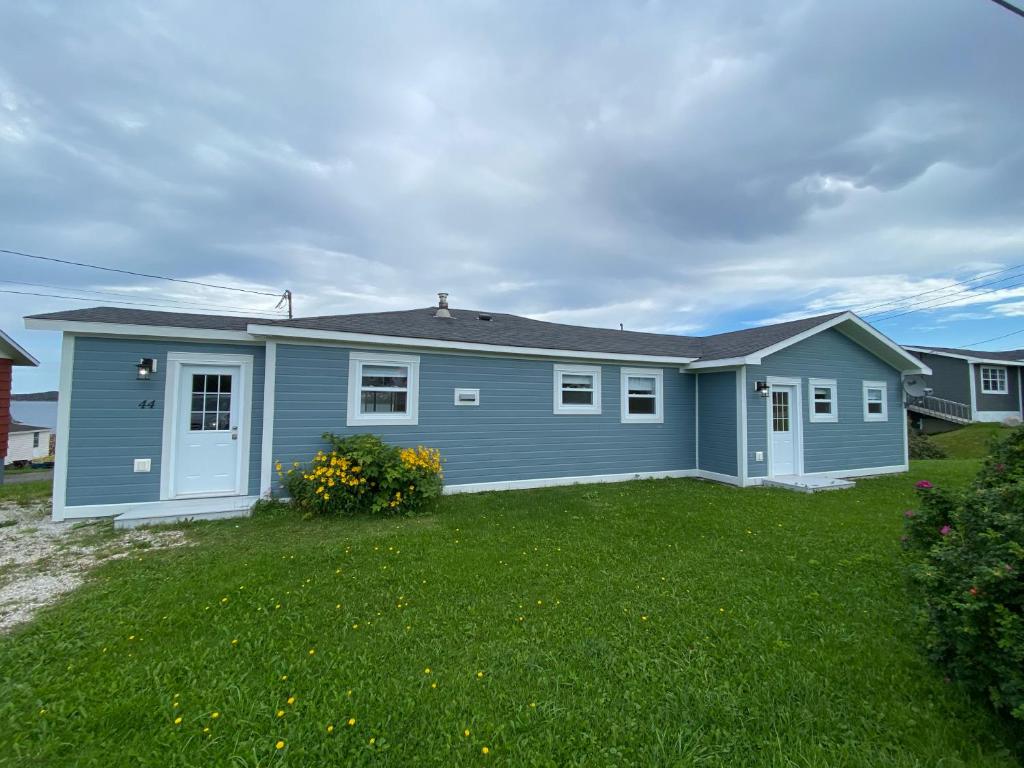 una casa azul con patio en Rocky Harbour Oceanfront, en Rocky Harbour