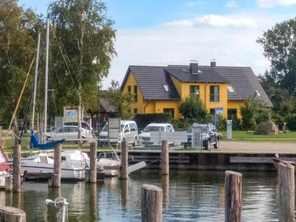 a marina with boats and a yellow house at Ferienhaus Bodden in Neuendorf