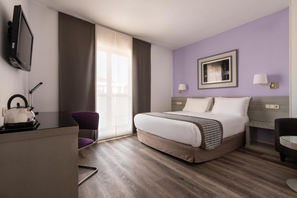 um quarto de hotel com uma cama e uma televisão em Exe Salamanca em Salamanca