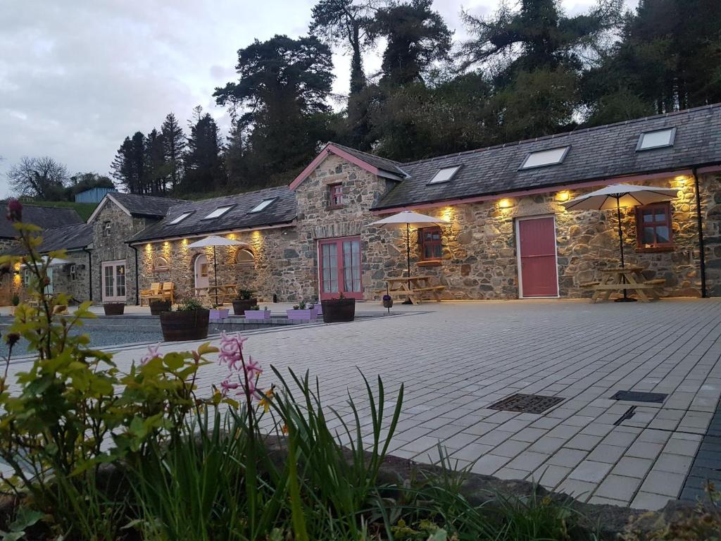 um edifício de pedra com um pátio em frente em Magical 3-Bed Stone Built Cottage - Sleeps 6 em Ballynahinch