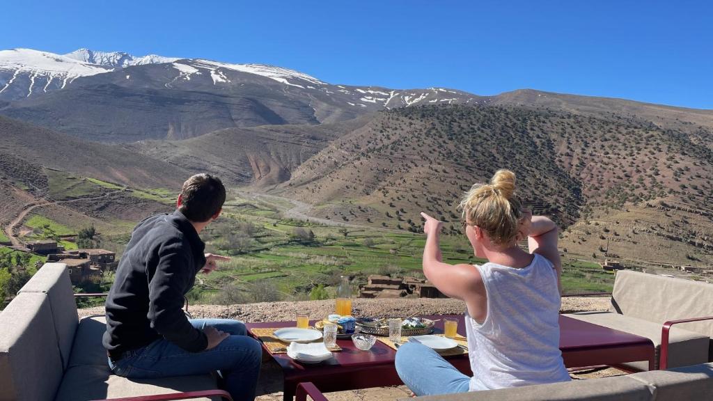 un hombre y una mujer sentados en la cima de una montaña en Touda Ecolodge Atlas Mountains en Zawyat Oulmzi