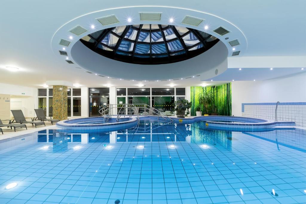 einen Pool in einem Gebäude mit einer Decke in der Unterkunft Napfeny Hotel in Zalakaros