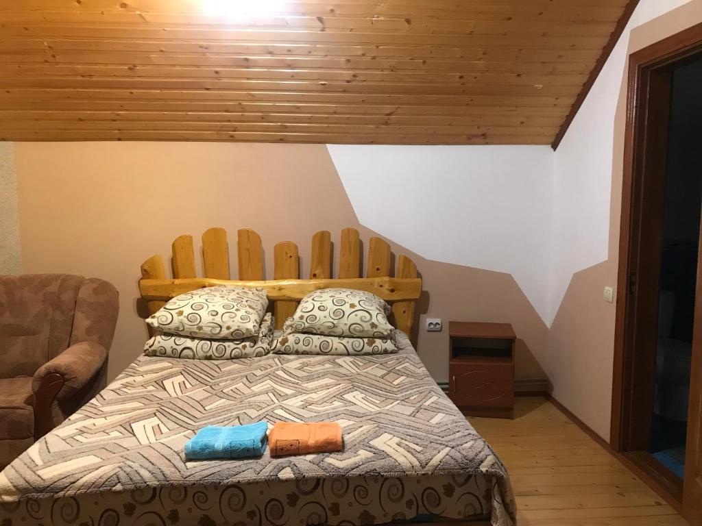 a bedroom with a bed with a wooden headboard at Milana Guesthouse in Slavske