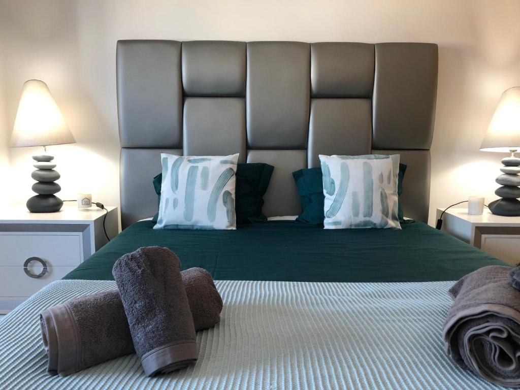 費雷爾的住宿－The Haven Baleal，卧室配有带白色枕头的大型绿色床