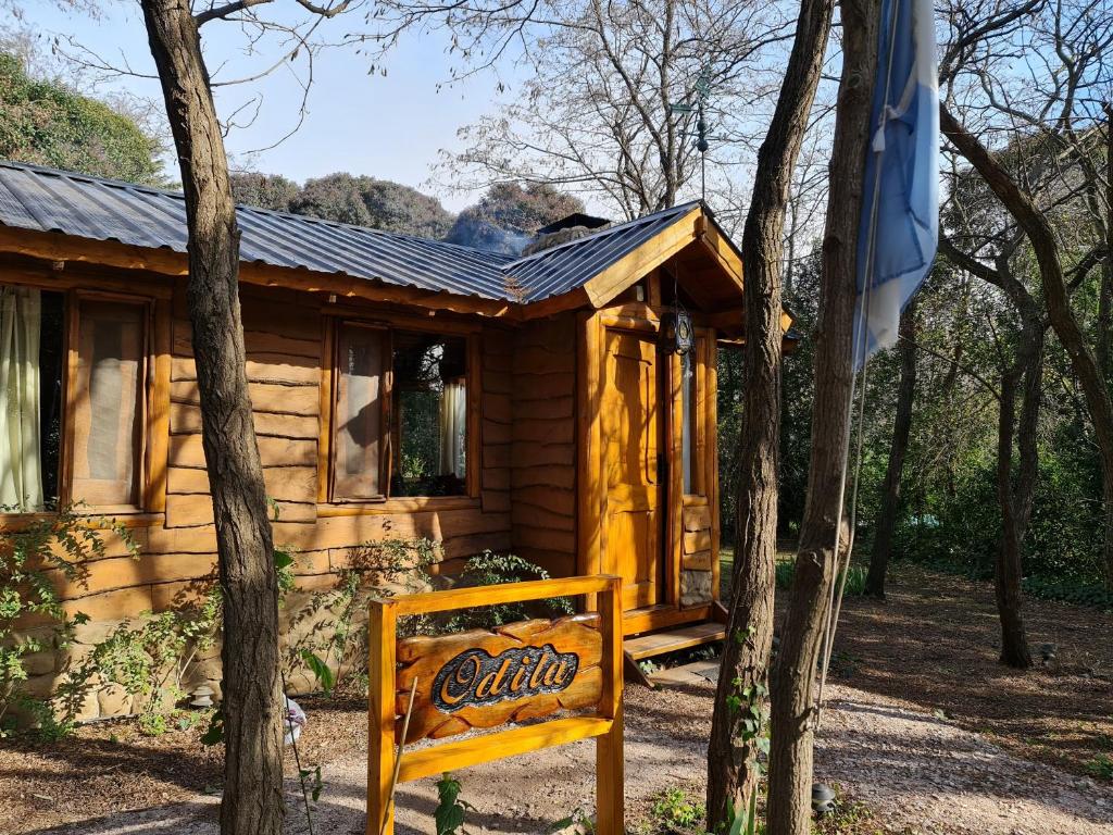 una cabaña de madera con un cartel delante en Cabaña Odila en Villa Ventana