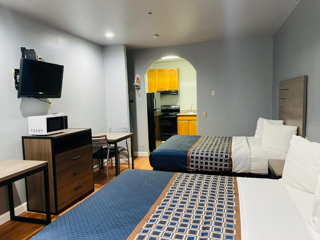 a hotel room with two beds and a kitchen at Palace Inn - Baytown I-10 in Baytown