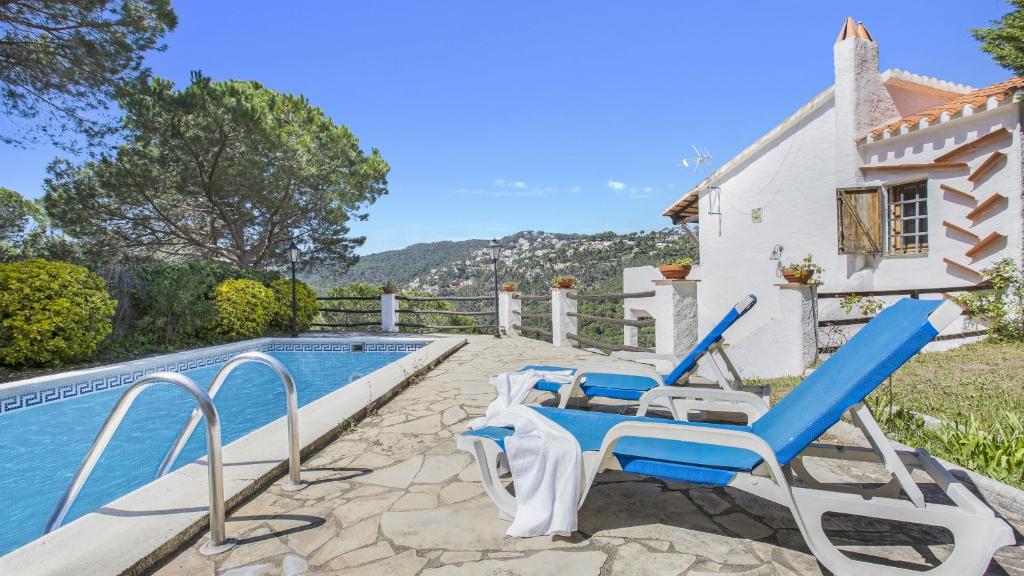 een villa met een zwembad en een huis bij 2ibi - Lloret de mar in Lloret de Mar
