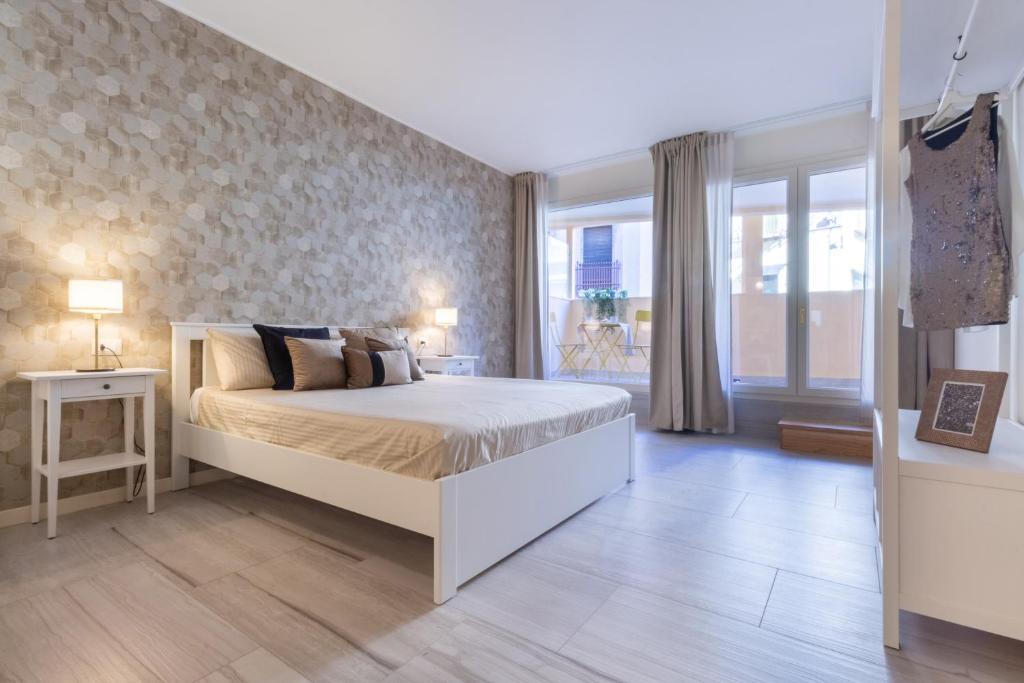 - une chambre avec un grand lit et une fenêtre dans l'établissement Studio Apartments Boutique Al Bastione di Cagliari, à Cagliari