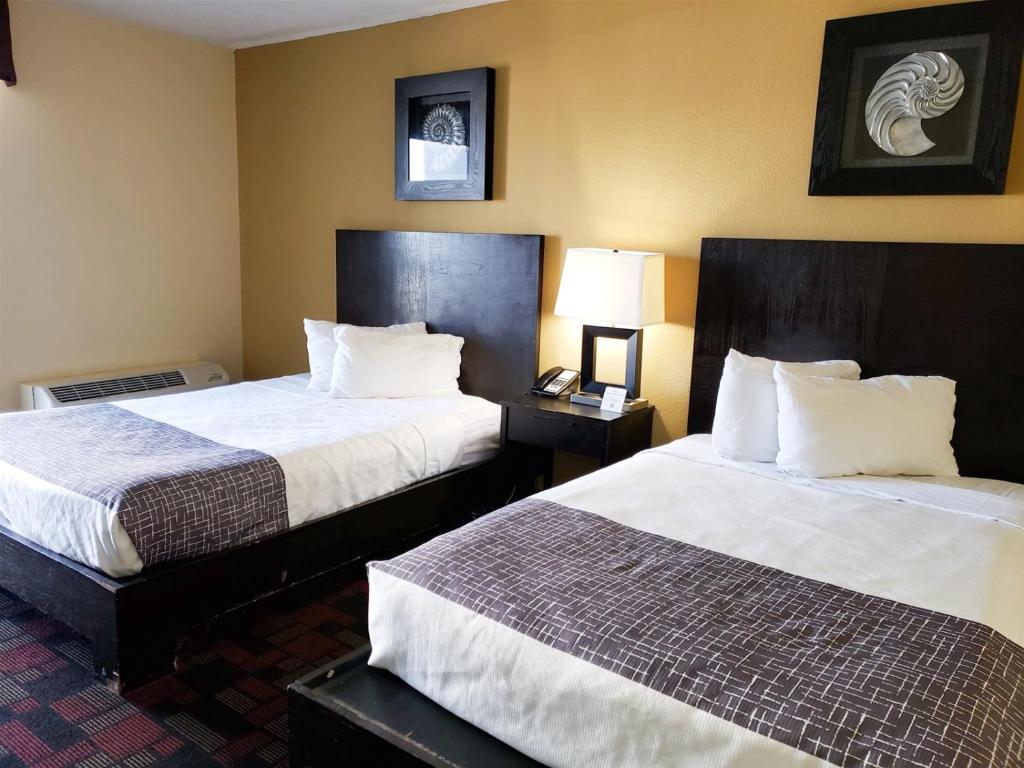 a hotel room with two beds and a lamp at Ocean View Studio-Sun N Sand 603 in Myrtle Beach