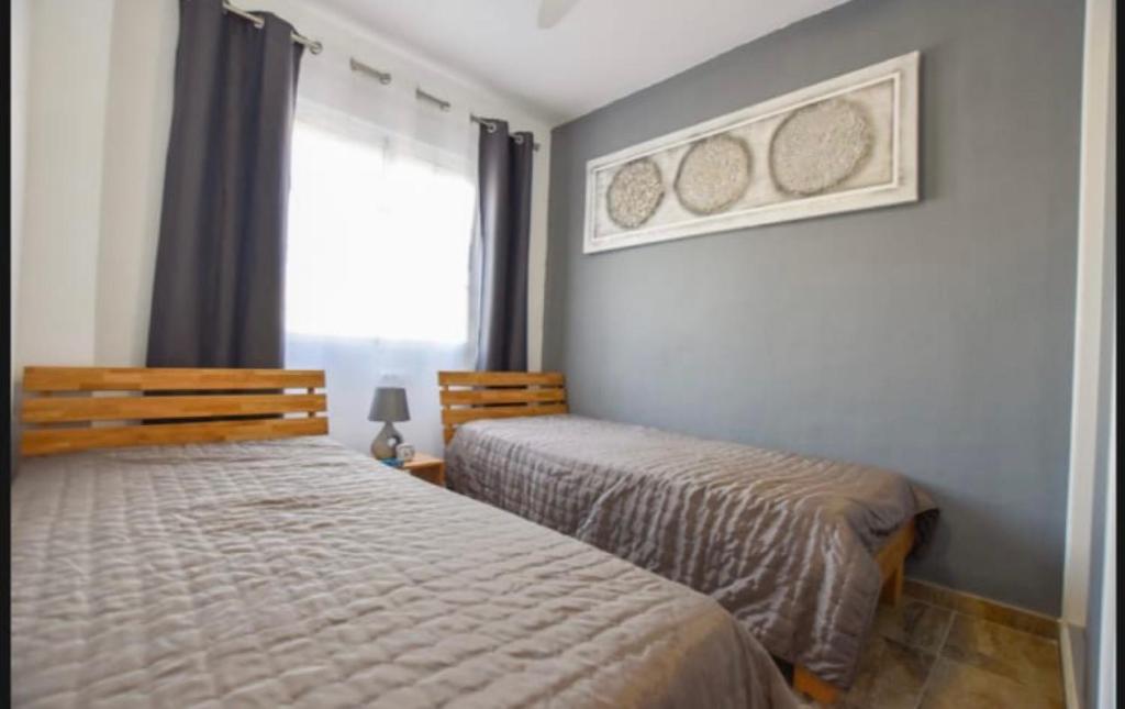 sypialnia z dwoma łóżkami i oknem w obiekcie Casa Sol y Luna w mieście Gran Alacant