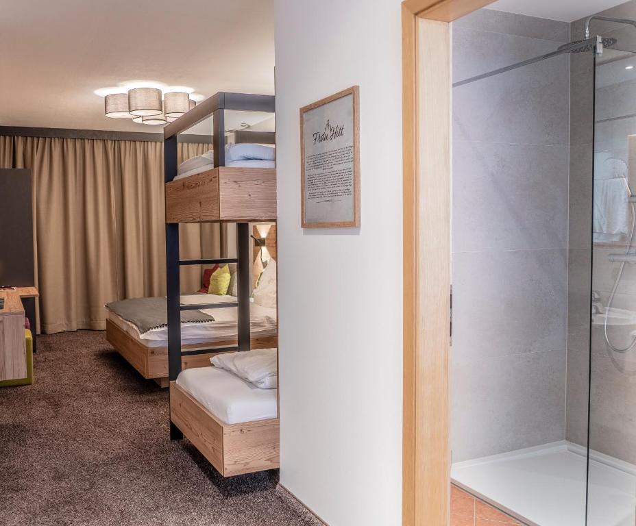 a room with two bunk beds and a shower at Sweet Cherry - Boutique &amp; Guesthouse Tyrol in Innsbruck