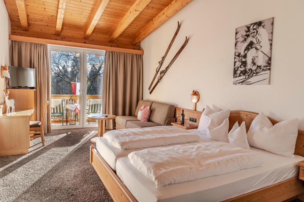 a bedroom with a large bed and a couch at Sweet Cherry - Boutique &amp; Guesthouse Tyrol in Innsbruck