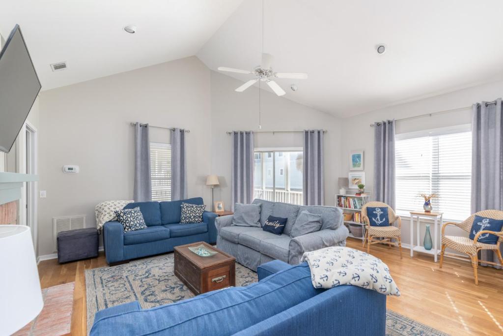 sala de estar con sofás azules y ventilador de techo en Trudy's Treasure, en Tybee Island