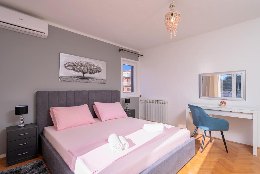 a bedroom with a large bed and a blue chair at Villa M&M - ZF Hvar in Hvar