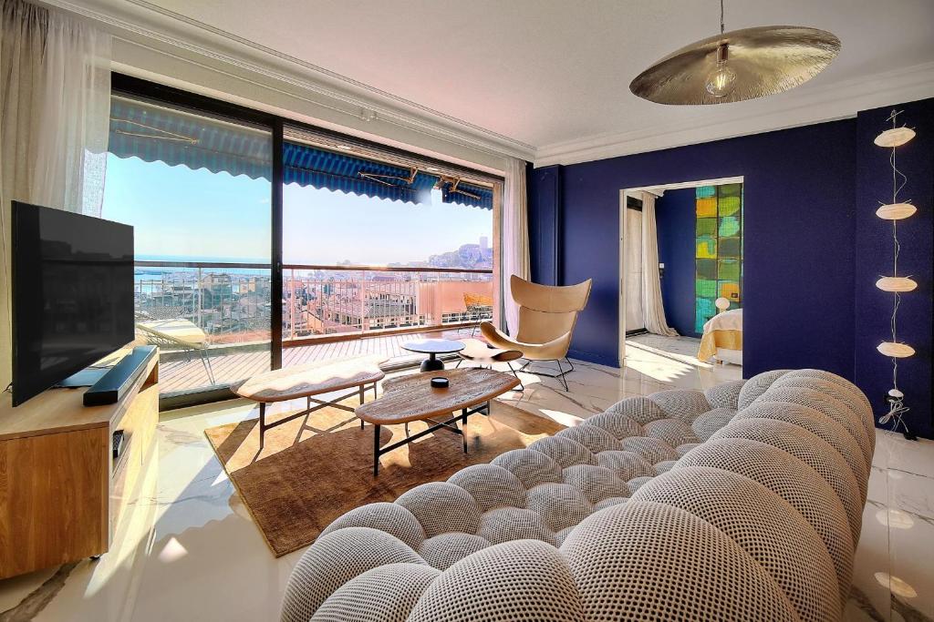 un salon avec un canapé et une grande fenêtre dans l'établissement Cannes Luxury Rental - Magnificent Apartment With Sea View, à Cannes