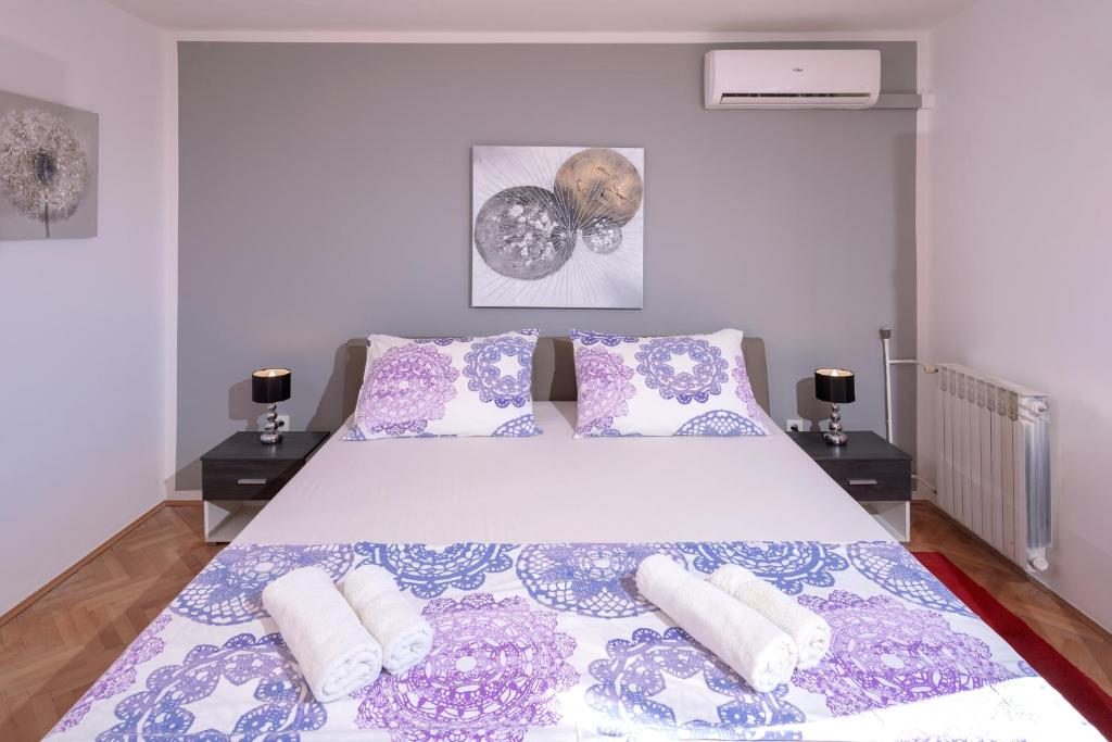 a bedroom with a bed with purple and white pillows at Villa M&M - ZF Hvar in Hvar