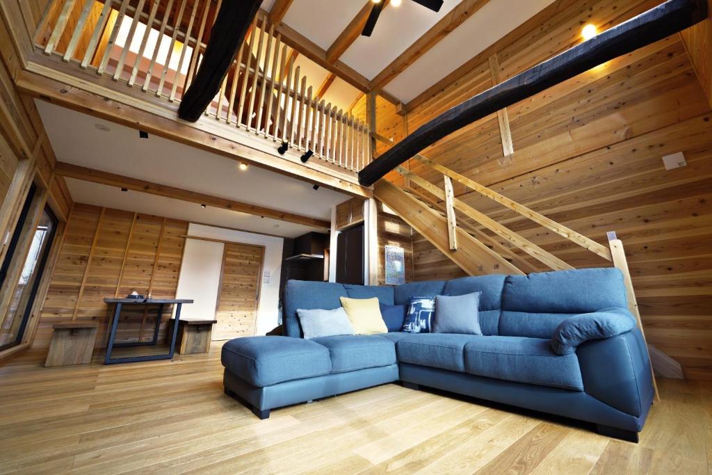 a blue couch in a room with wooden walls at Tombi Lodge - Vacation STAY 14464v in Iiyama
