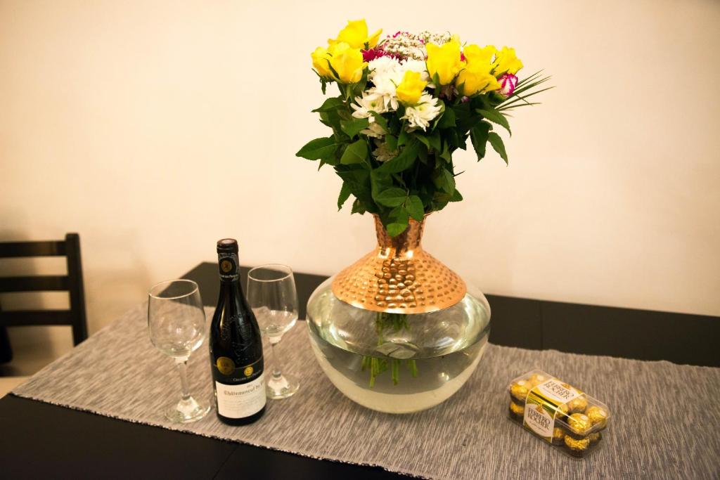 a vase with flowers and a bottle of wine on a table at Exchange Suite Downtown in Dublin