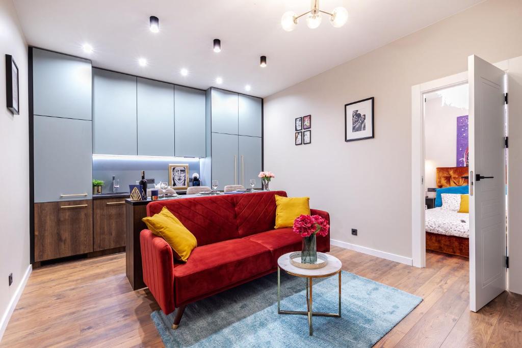 a living room with a red couch and a kitchen at Lovely apartment Traku str. in Vilnius