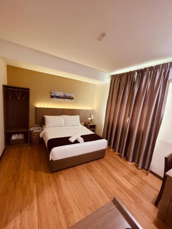 Postel nebo postele na pokoji v ubytování LABUAN JATI HOTEL