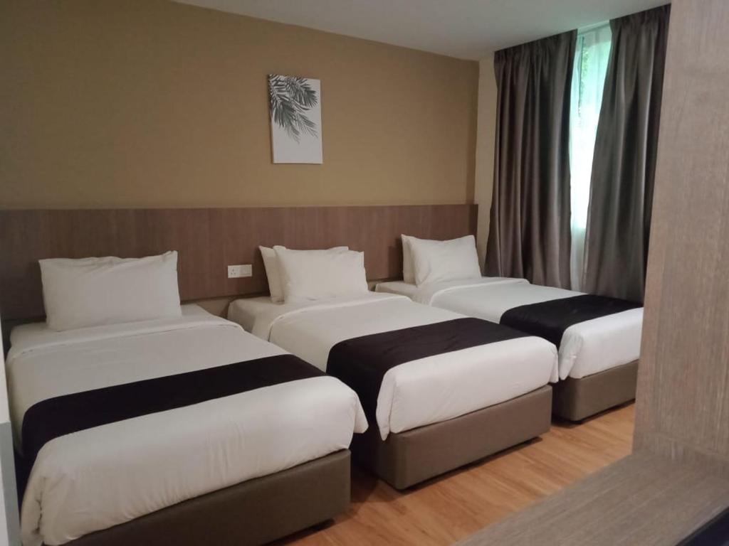 pokój hotelowy z 3 łóżkami w pokoju w obiekcie LABUAN JATI HOTEL w mieście Labuan