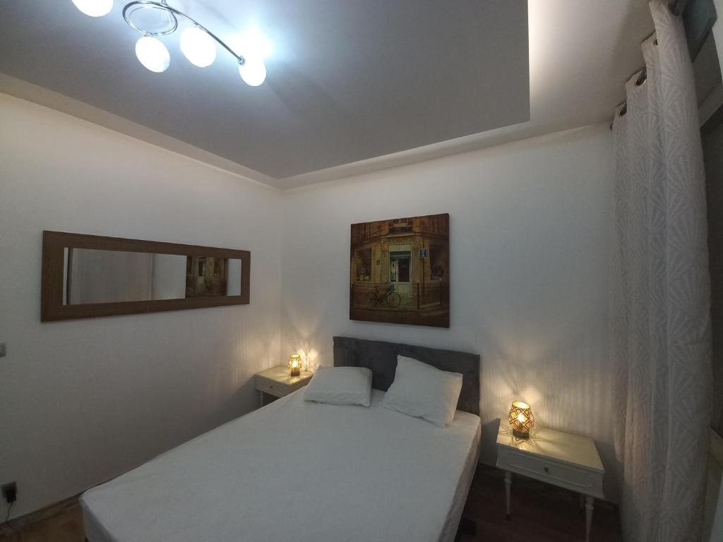 a bedroom with a white bed and two night stands at Le Gerwig Colmar Centre in Colmar