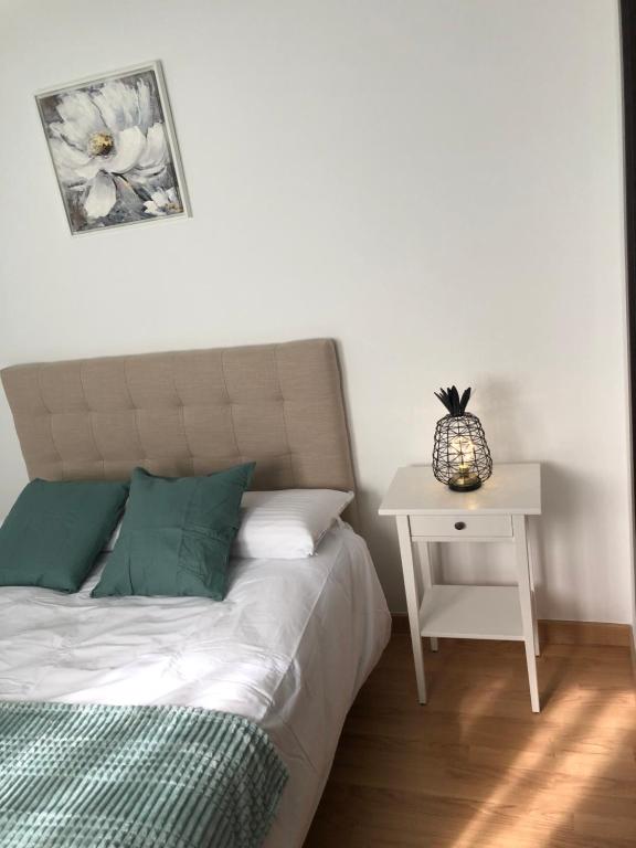 1 dormitorio con 1 cama y mesita de noche con mesa en Apartamento Maracena Centro, en Maracena