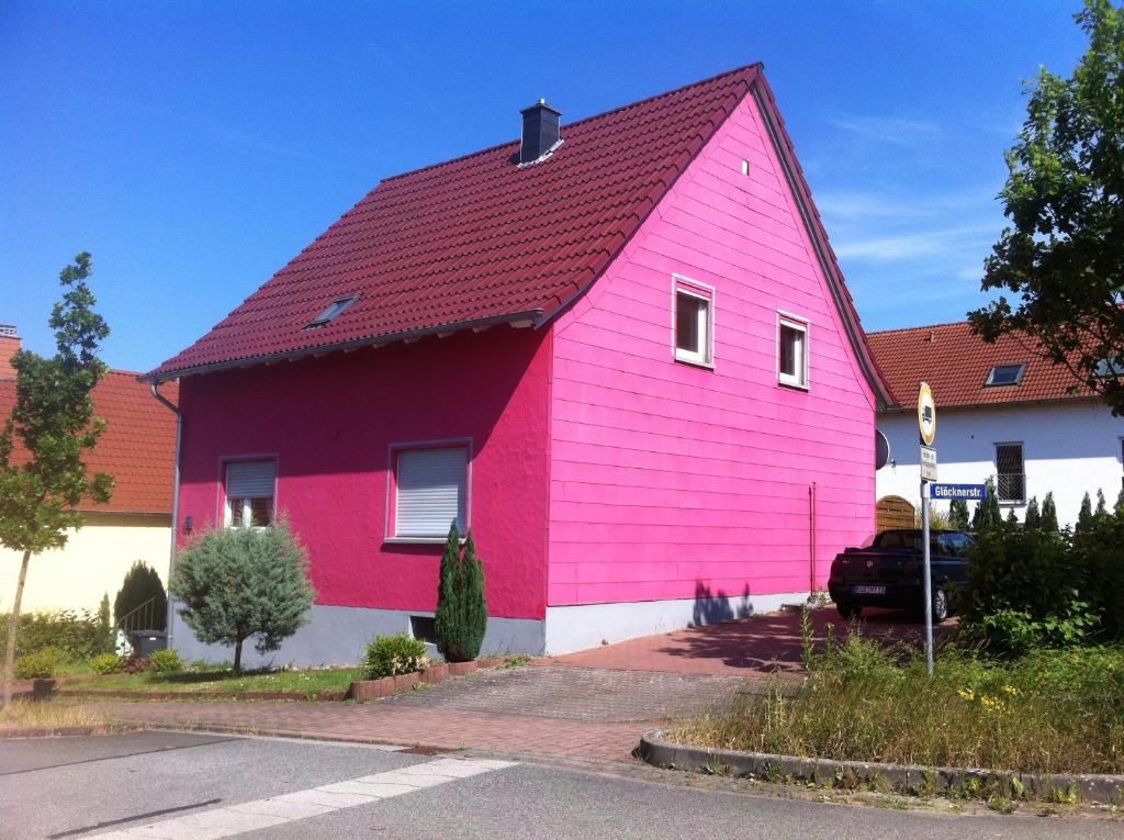 a pink house with a red roof on a street at Gästehaus Waldmohr in Waldmohr