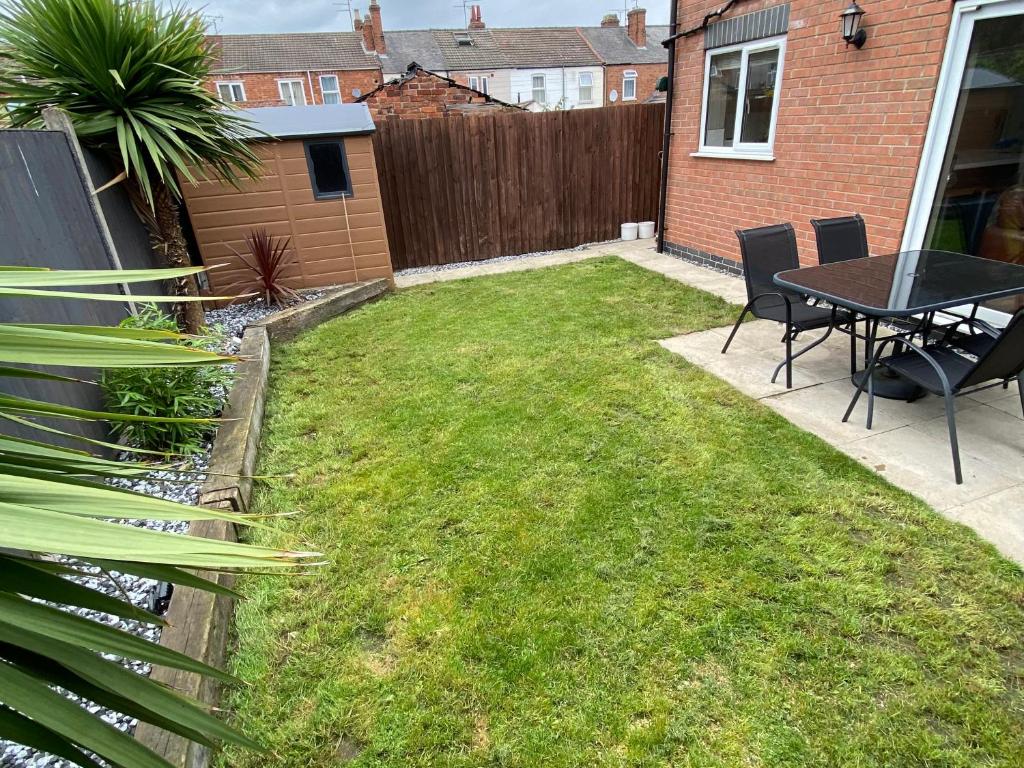 a backyard with a table and chairs and a fence at Comfortable modern 1bed house 5 mins from centre in Lincoln