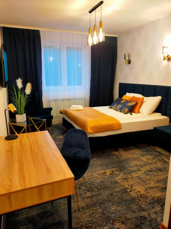 a hotel room with a bed and a table at Wrzos in Poznań
